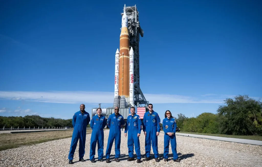 Artemis II Moon Mission Crew and SLS Rocket Rollout 2026. Prime and backup astronauts for the Artemis II moon mission standing in front of the SLS rocket and Orion spacecraft at NASA's Kennedy Space Center.